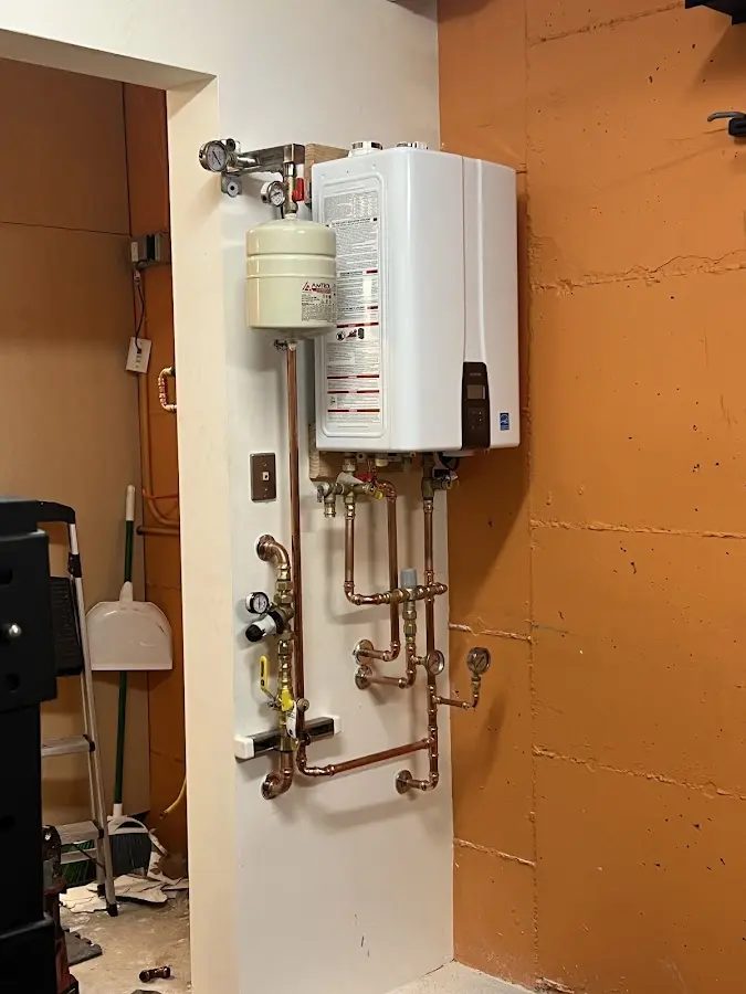 Plumbing technician inspecting water heater connections in Pocono